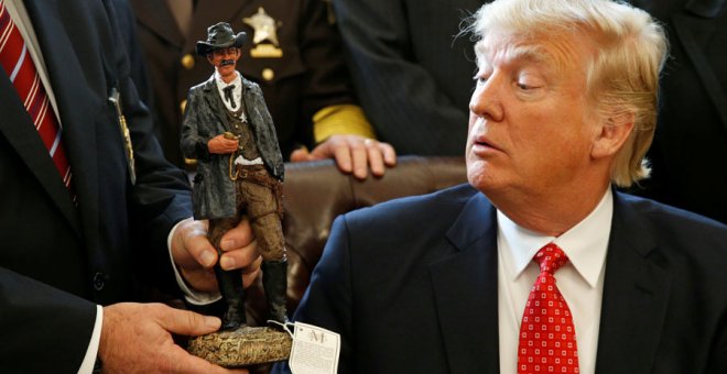 Trump recibe una figura de un sheriff durante una reunión en la Casa Blanca. REUTERS/Kevin Lamarque