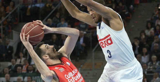 El ala pivot del Valencia Basket, Pierre Oriola (i), intenta encestar ante la defensa del pivot estadounidense del Real Madrid, Anthony Randolph, durante el encuentro correspondiente a la final de Copa del Rey, que disputan esta tarde en el Fernando Buesa