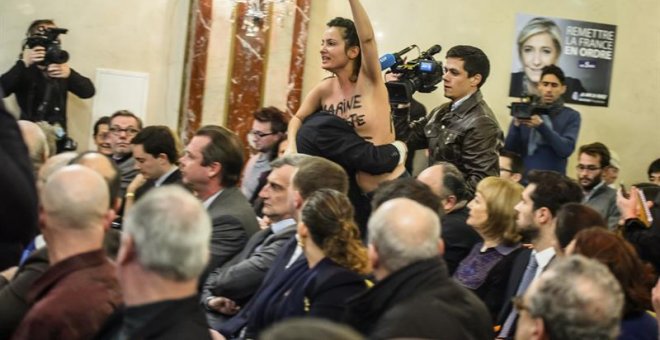 Una activista del grupo feminista Femen interrumpe la rueda de prensa de la líder del partido de extrema derecha Frente Nacional y candidata presidencial, Marine Le Pen (no en la imagen), durante una rueda de prensa sobre las políticas de exteriores del p