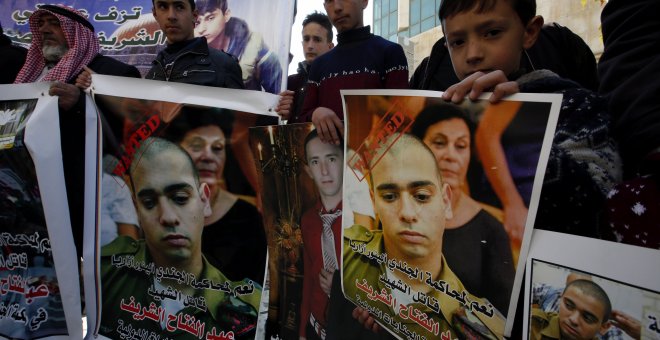 Palestinos sostienen pancartas con la imagen del soldado israelí Elor Azaría, durante una protesta en la ciudad cisjordana de Hebrón. EFE/ABED AL HASLHAMOUN