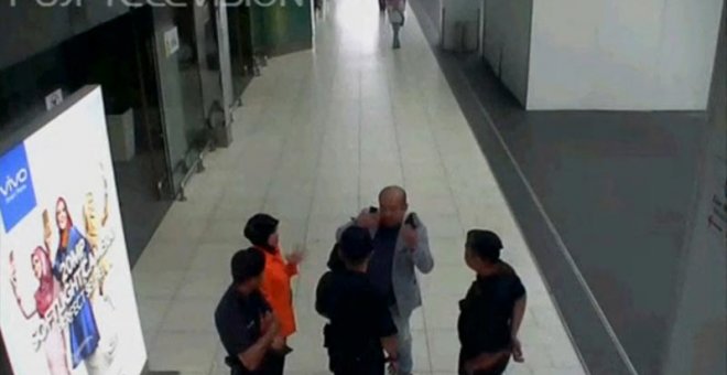 Kim Jong-nam, con traje gris, habla con agentes de seguridad del aeropuerto de Kuala Lumpur el día que fue intoxicado por el veneno VX. | REUTERS