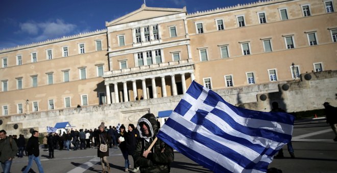 Un agricultor, con la bandera nacional griega, en la ateniense Plaza de Syntagma, donde está el Parlamento, tras una manifestación reclamando la bajada de impuestos.. REUTERS/Alkis Konstantinidis