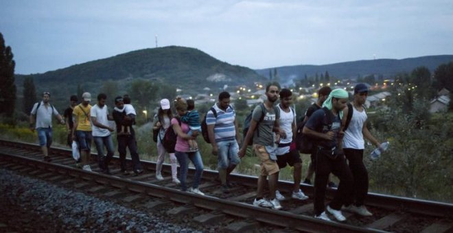 Inmigrantes caminan por las vías hacia la frontera de Austria. EFE/Balasz Mohai