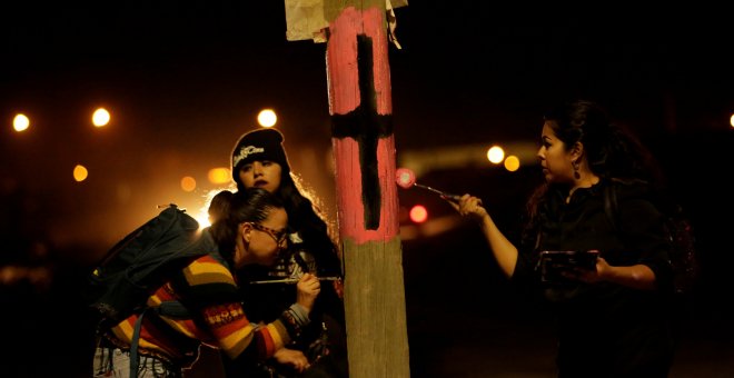 Unas activistas pintan una cruz negra en una farola para recordar a las víctimas de violencia machista con motivo del Día Internacional de la Mujer en Ciudad Juárez, Mexico. REUTERS/Jose Luis Gonzalez