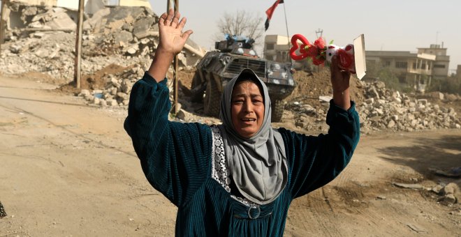 Una mujer levanta los brazos en medio de la batalla en Mosul (Irak). /REUTERS