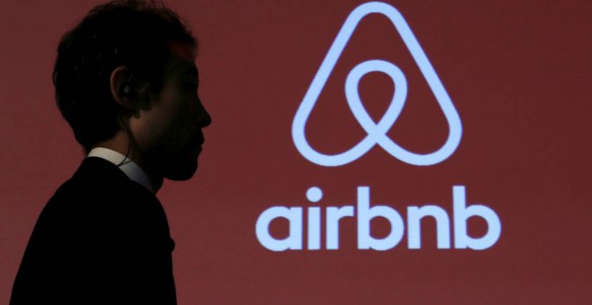 La sombra de una persona frente al logotipo de AirBnB. EFE