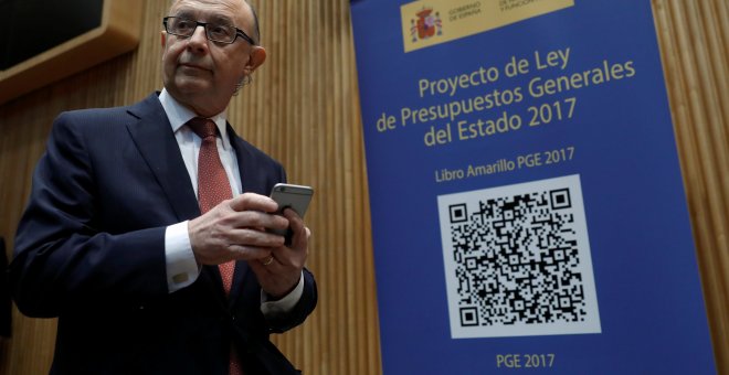 El ministro de Hacienda, Cristóbal Montoro, se prepara para escanear con el móvil el código QR del proyecto de Ley de Presupuestos Generales del Estado (PGE) para 2017. REUTERS/Juan Medina