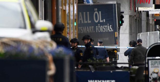En esta imagen se puede ver el camión empotrado contra un edificio rodeado de policías. | AFP