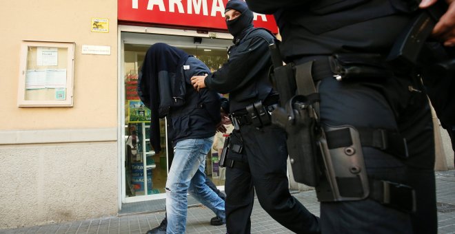 Uno de los detenidos es llevado por los agentes tras la operación antiyihadista en Barcelona.- REUTERS