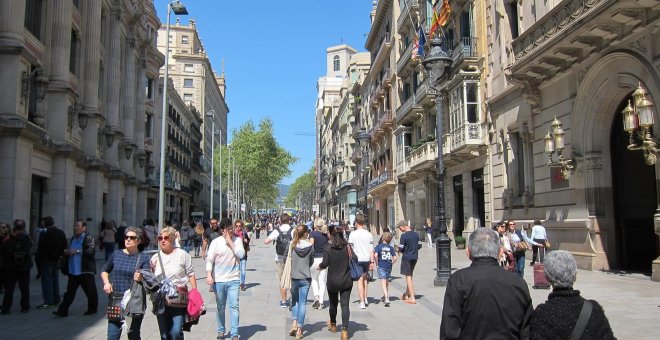 Paseantes recorren una calle de Barcelona