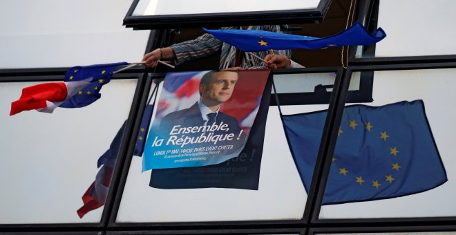 Uno de los carteles de campaña de Emmanuel Macron rodeado de banderas de la Unión Europea.- REUTERS