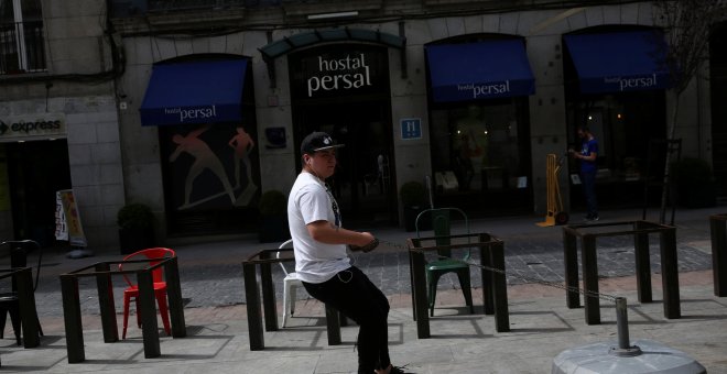 Un trabajador arrastra el soporte de una sombrilla para una terraza de una cafetería en el centro de Madrid. REUTERS/Susana Vera