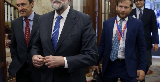 El presidente del Gobierno, Mariano Rajoy (c), acompañado del portavoz del PP, Rafael Hernando (i), tras la aprobación  del proyecto de Presupuestos para 2017. EFE/Kiko Huesca
