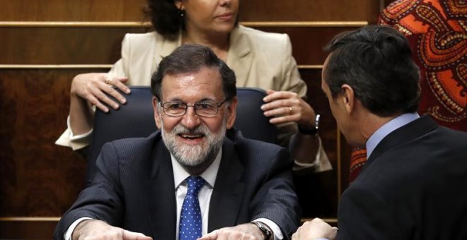 El presidente del Gobierno, Mariano Rajoy,c., el portavoz del Grupo Parlamentario Popular, Rafael Hernando,d., y la vicepresidenta del Gobierno, Soraya Saénz de Santamaría, detrás, durante la última jornada de debate y votación en el Congreso de los Pre