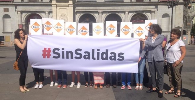 Representantes de las diez organizaciones firmantes sostienen una pancarta bajo el lema 'Sin salidas' con el que quieren simbolizar la situación de las personas refugiadas. PÚBLICO