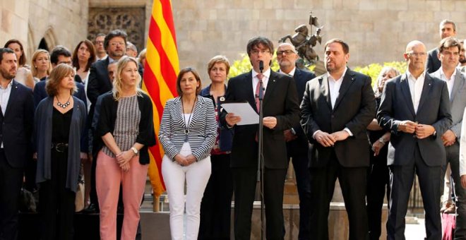 Carles Puigdemot anuncia la fecha del referéndum en el Palacio la Generalitat acompañado por los miembros de su Gobierno. | ALBERT GEA (REUTERS)