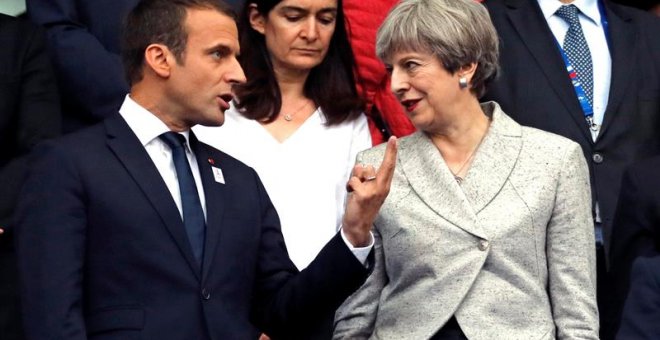 El presidente francés Emmanuel Macron (izda) y la primera ministra británica Theresa May asisten a un partido de fútbol amistoso entre las selecciones de ambos países en el estado Stade de France. /EFE