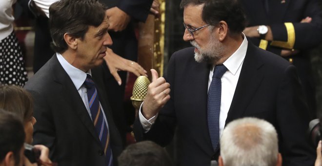 El presidente del Gobierno, Mariano Rajoy, conversa con el portavoz parlamentario del PP, Rafael Hernando, tras la votación de la moción de censura. EFE/Ballesteros