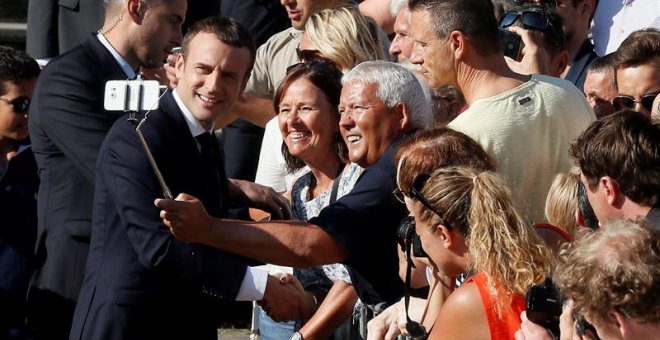 Emmanuel Macron se hace un selfi al llegar a su colegio electoral para votar en la segunda vuelta de las legislativas francesas. /EFE