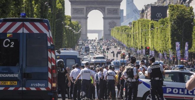 Agentes de policía galos permanecen en guardia en la céntrica avenida de los Campos Elíseos, donde un coche ha impactado contra un furgón de la Gendarmería francesa. EFE/Christophe Petit Tesson