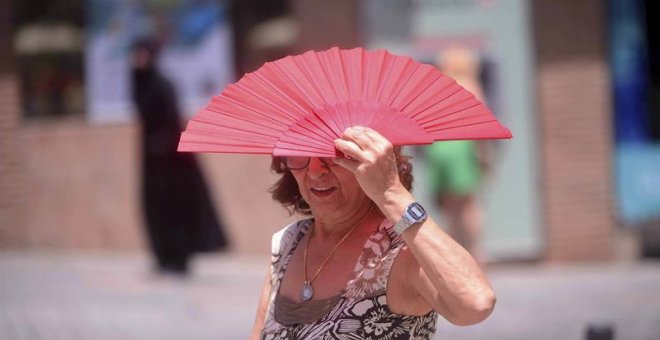 Una mujer se protege del sol en Córdoba. - EFE