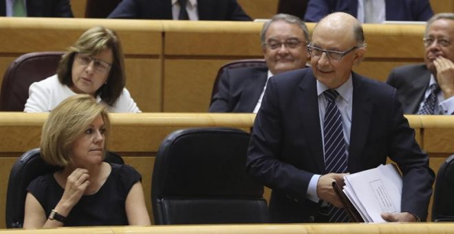El ministro de Hacienda, Cristóbal Montoro y la titular de Defensa, María Dolores de Cospedal, durante la sesión de control al Gobierno en el pleno del Senado. /EFE
