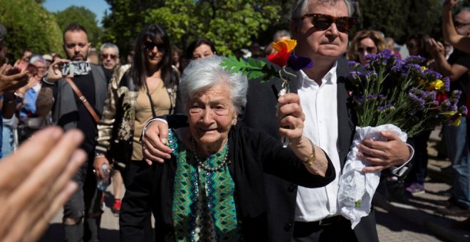 La lucha de una vida. Ascensión levanta unas flores con los colores republicanos junto a su hijo.- REUTERS