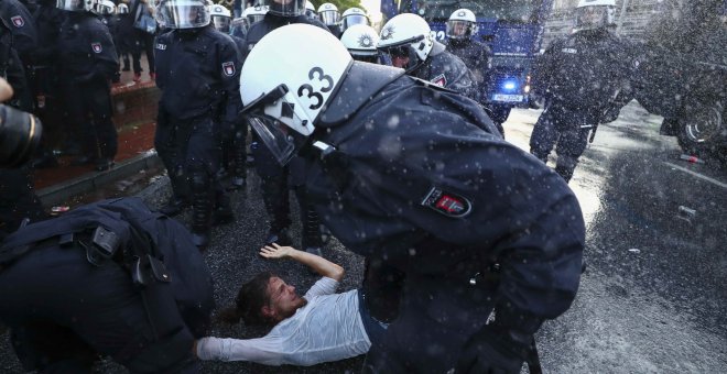 Varios agentes antidisturbios cargan contra un manifestante en Hamburgo. /REUTERS