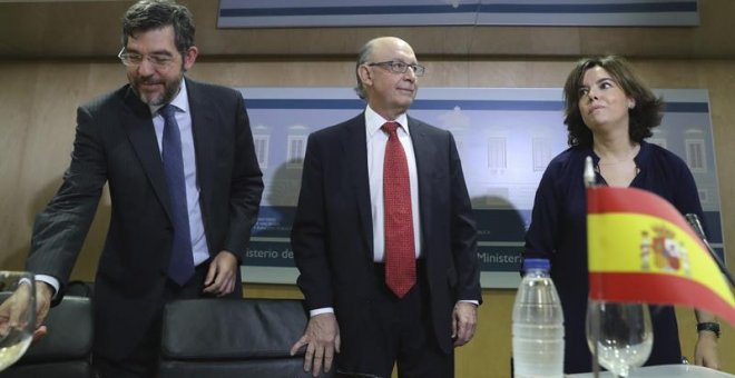 El ministro de Hacienda, Cristóbal Montoro (c), la vicepresidenta del Gobierno, Soraya Sáenz de Santamaría, y el secretario de Estado de Presupuestos, Alberto Nadal (i), al inicio de la reunión del Consejo de Política Fiscal y Financiera (CPFF) que el gob