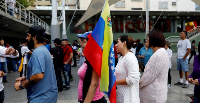 Una mujer con una bandera de Venezuela hace cola para votar en el Plebiscito (no oficial) contra el Gobierno de Nicolás Maduro.REUTERS/Andrés Martínez Casares