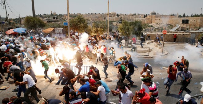 Manifestantes palestinos corren después de que las tropas israelís lanzasen bombas de gas lacrimógeno. REUTERS/Ammar Awad