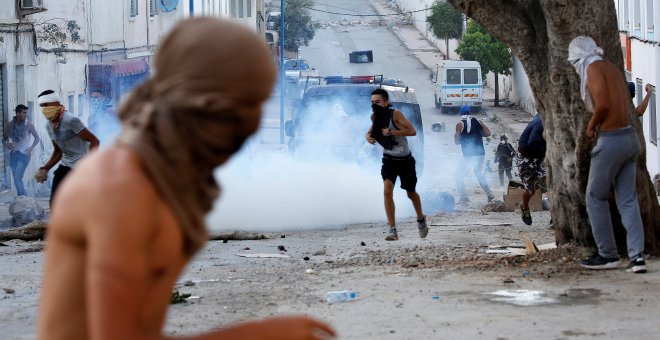 Manifestantes encapuchados lanzan piedras a la Policía antidisturbios durante la multitudinaria protesta en Alhucemas, Marruecos, el pasado 20 de julio.- REUTERS