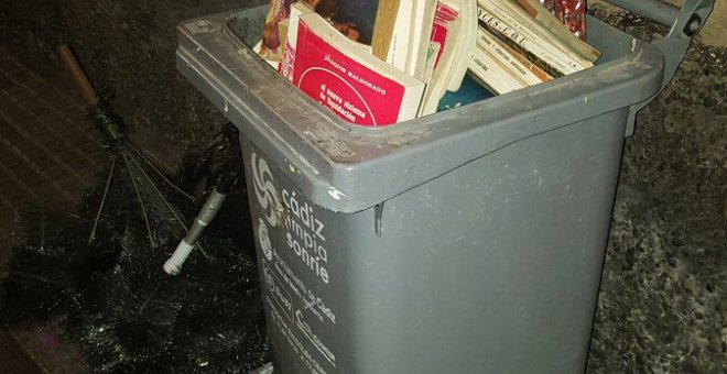 Montones de libros en un contenedor de basura