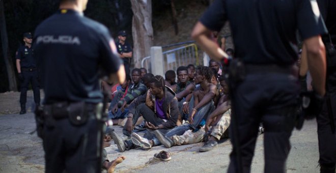 La Policía frente al grupo de migrantes después de saltar la valla de Ceuta / REUTERS