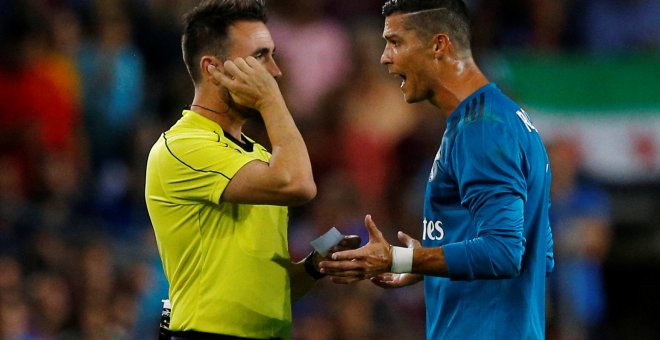 El jugador del Real Madrid Cristiano Ronaldo protesta ante el árbitro Ricardo de Burgos Bengoetxea por su expulsión en el partido de ida de la Supercopa de España en el Nou Camp. REUTERS/Juan Medina