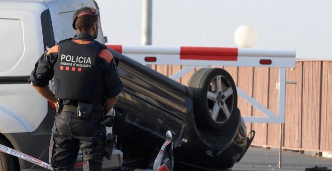 Un agente, junto al coche que usaron los terroristas en su ataque en Cambrils. - AFP