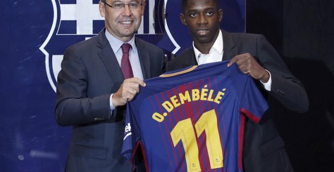 El nuevo fichaje del FC Barcelona, el francés Ousmane Dembélé (d), muestra hoy con el presidente del FC Barcelona, Josep Maria Bartomeu (i) la camiseta que llevará como jugador del equipo azulgrana. EFE/ Andreu Dalmau