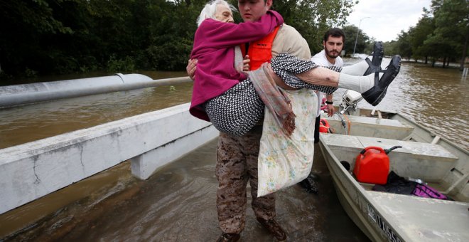 Un hombre ayuda a una anciana damnificada por Harvey en Houston. REUTERS/Carlo Allegri