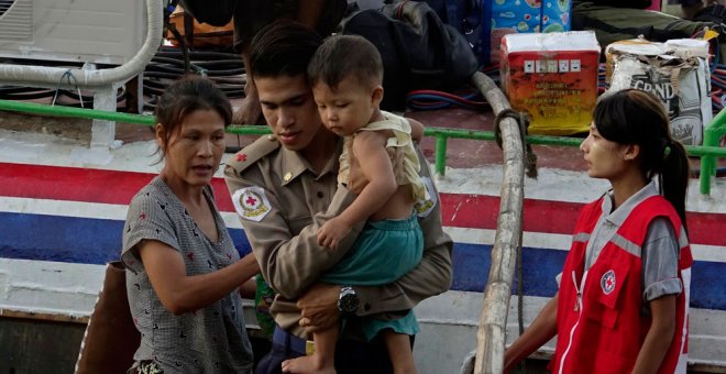 Voluntarios de la Cruz Roja asisten a un niño desplazado de la aldea de Maungdaw a su llegada al puerto de Sittwe, en Rakhine, al oeste de Birmania. EFE