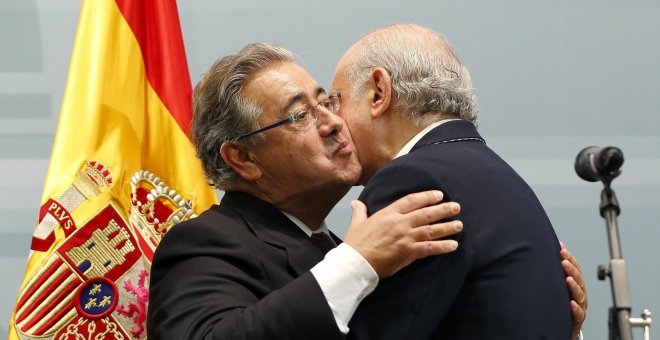 Zoido se abraza a su antecesor en el cargo, Fernández Díaz. | EFE