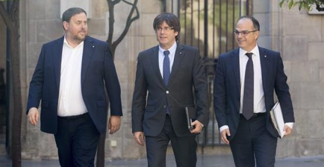 El presidente de la Generalitat, Carles Puigdemont (c), junto al vicepresidente y conseller de Economía, Oriol Junqueras (i), y el conseller de la Presidencia, Jordi Turull (d), se dirigen hoy a la reunión semanal del Govern. EFE/Marta Pérez
