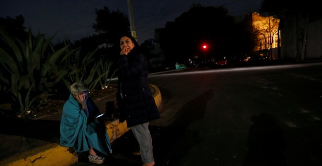 Dos personas esperan en la calle tras el fuerte sismo detectado en Ciudad de México. REUTERS/Claudia Daut