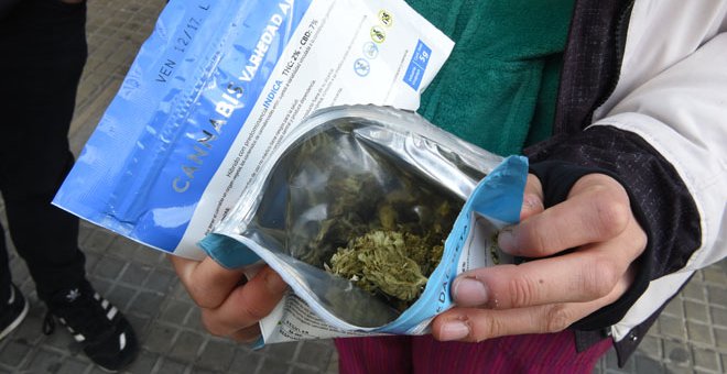 Un hombre muestra un sobre con marihuana comprada en una farmacia de Montevideo /AFP (MIGUEL ROJO)
