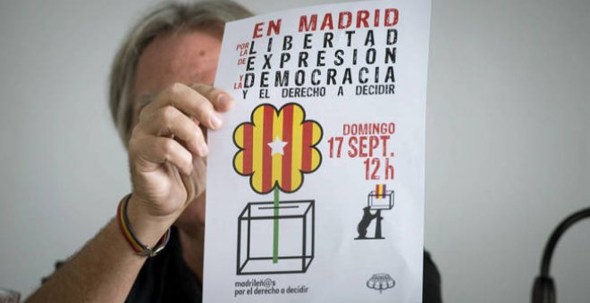 Un activista muestra el cartel del acto de 'Madrileños por el derecho a decidir', en una rueda de prensa este miércoles. EFE