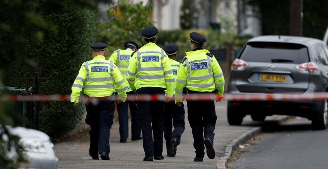 Policías caminan detrás del cordón de seguridad instalado en las casa del segundo sospechosos detenido en relación con el atentado en el metro de Londres. REUTERS/Peter Nicholls