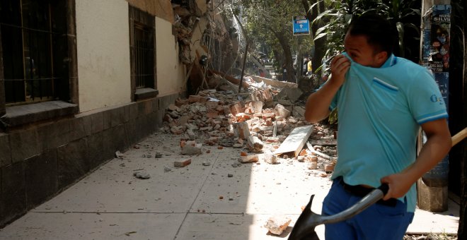 Un hombre se tapa la cara junto a un edificio derruido tras el terremoto en Ciudad de México. - REUTERS