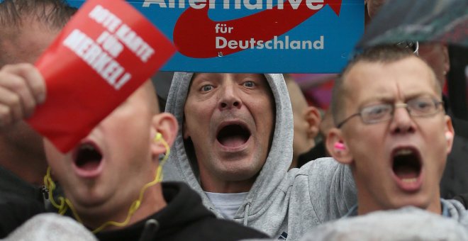 Simpatizantes de Alternativa para Alemania (AfD) gritan durante un acto de campaña de la canciller alemana Angela Merkel el 6 de septiembre del 2017. REUTERS/ Reinhard Krause