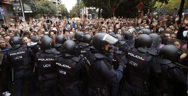 Agentes antidisturbios de la Policía Nacional forman un cordón de seguridad en los alrededores del colegio Ramón Llull de Barcelona. | EFE