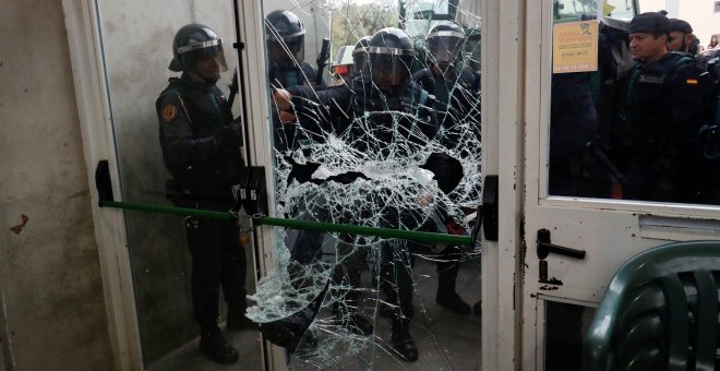 La Policía destroza la puerta del colegio electoral donde tenía que votar Carles Puigdemont./ REUTERS