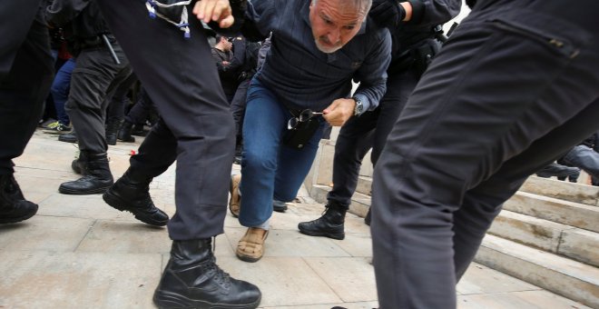 Agentes de la Guardia Civil tiran de un ciudadano frente a un colegio electoral en Sant Julia de Ramis, este domingo. REUTERS/Albert Gea